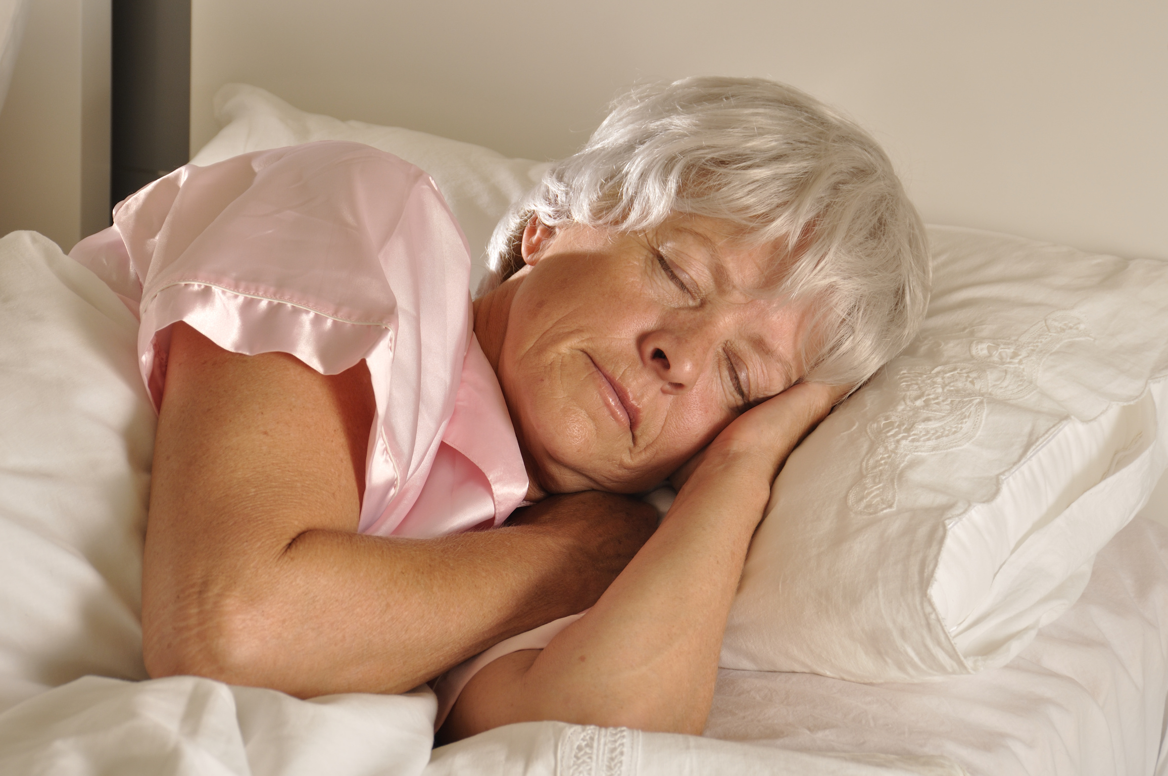 Seniorin schläft in einem Bett