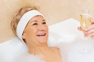 Gute gelaunte Senioren mit Sekt in Badewanne