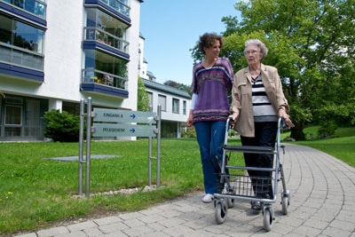 Seniorin vor Pflegeheim