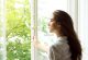Junge Frau an offenem Fenster Junge Frau an offenem Fenster