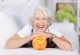 Lachende Seniorin mit Sparschwein Lachende Seniorin mit Sparschwein