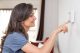 Frau regelt digitales Thermostat Frau regelt Thermostat